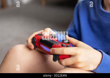 Close-up of a boy's hands holding a game controller. Video games, game consoles. Stock Photo