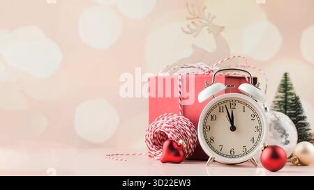 Christmas composition with holiday decorations, alarm clock and gift box. Copy space Stock Photo