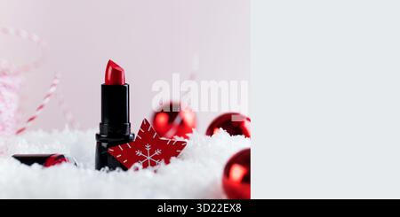 Christmas banner with red lipstick on the snow and Christmas balls. Copy space. Stock Photo