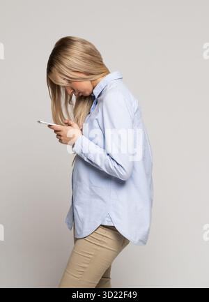 Young woman looking and using smart phone with scoliosis,. Incorrect and bad posture, scoliosis Stock Photo