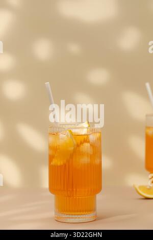 A glass of cold tea, ice cubes, lemon slices. Cooling summer drinks. Stock Photo
