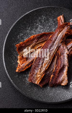 Dried salted fish as snacks or jerky, seafood as slices. Dried seafood snacks Stock Photo