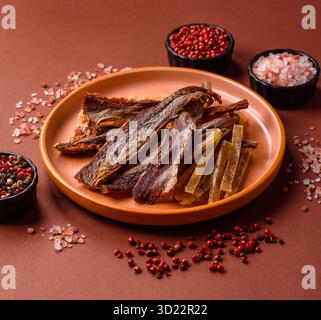 Dried salted fish as snacks or jerky, seafood as slices. Dried seafood snacks Stock Photo