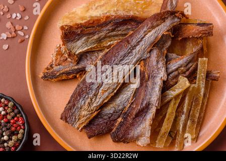 Dried salted fish as snacks or jerky, seafood as slices. Dried seafood snacks Stock Photo