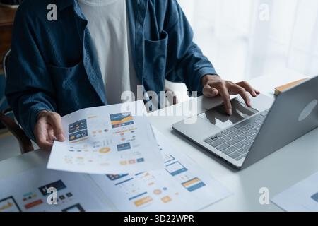 UX UI Designer Planning innovative Mobile App with Paper Wireframe Designs at Workspace. Stock Photo