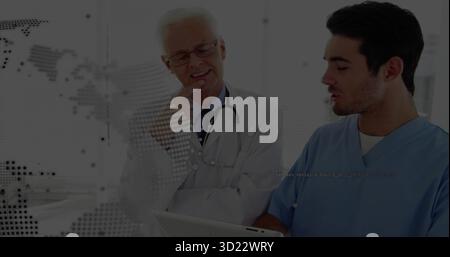 Reviewing tablet, physician in white coat and doctor in blue scrubs working in clinic stethoscope Stock Photo