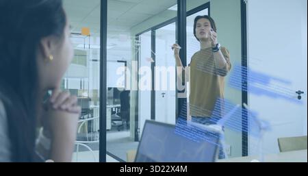 Writing engineer coding diagrams on glass board in meeting room, with markers laptop sticky notes Stock Photo