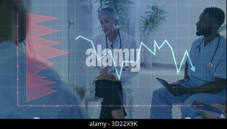 Taking notes senior female doctor using clipboard and pen in consultation room, with digital charts Stock Photo