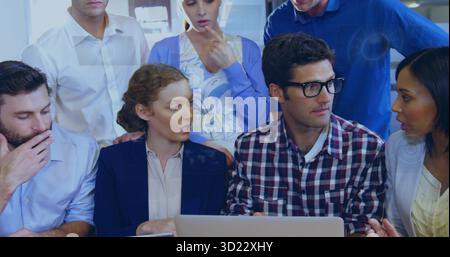 Discussing project ideas coworkers leaning toward laptop in conference room, business casual Stock Photo