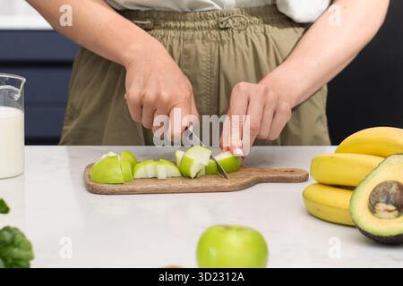 Healthy cooking with fresh fruit, cutting green apples on a cutting board Stock Photo
