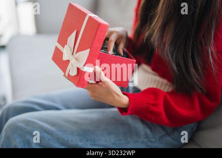 Receiving Valentine present. Cheerful girl asian holding gift box. Stock Photo