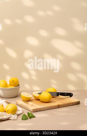 There is a juicy lemon cut in half with a knife on the board. Ripe yellow lemons Stock Photo
