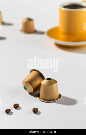 Coffee capsules with a cup and saucer in the background Stock Photo