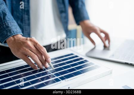 Businessman and Engineers Working on Solar Panels Project for Green Energy Accumulation in Eco-Friendly Office. Stock Photo