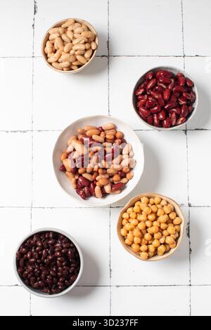 Assorted legumes arrangement on white tiled surface for healthy cooking Stock Photo