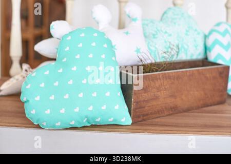 Decorative heart-shaped pillow with white polka dots on rustic wooden table Stock Photo
