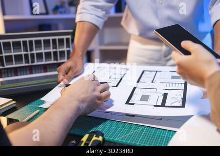 A group of engineers and architects collaborate on a construction project, discussing ideas and sharing technical plans to design innovative modern bu Stock Photo
