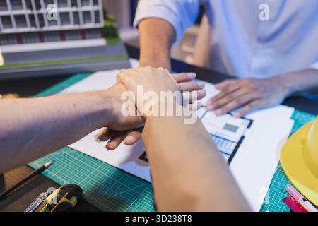 A group of engineers and architects collaborate on a construction project, discussing ideas and sharing technical plans to design innovative modern bu Stock Photo