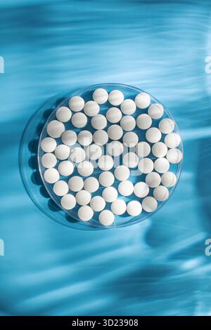 White round pills on a blue background background. Pills, minerals and vitamins. Stock Photo
