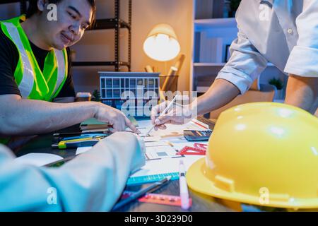 A diverse team of professionals shares ideas about architectural layouts and structural concepts, focusing on teamwork, creativity, and precision in m Stock Photo