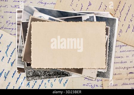 Stack old photos with blank copy space, lying on old letters. Abstract textured backdrop, postcard mockup. Stock Photo