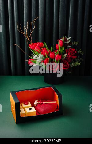 Beautiful gourmet gift box with heart-shaped dessert and flowers Stock Photo