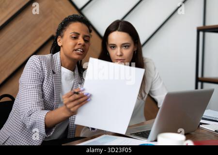 Two businesswomen at the workplace in the office work with documents Stock Photo