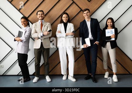 Smiling young motivated startup international employees group looking at camera. Stock Photo