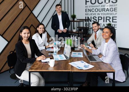 Young co-workers team talking during startup - Happy people planning a new project in creative workplace Stock Photo
