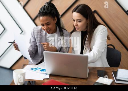 Female colleagues in the office at the workplace form a business report Stock Photo