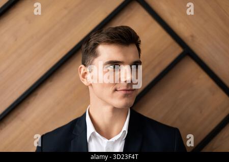 Young businessman talking on a mobile phone against the background of a modern office building with a smile on his face Stock Photo