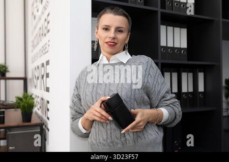 Business woman with a short haircut in the office with a stamp in her hands Stock Photo