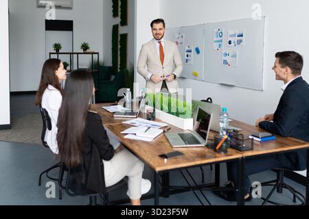 Brainstorming of employees of a startup company at a large table Stock Photo