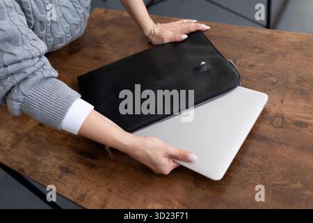 Graphic designer taking out laptop from leather case in office Stock Photo