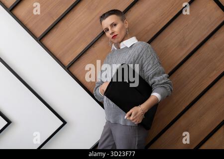 Portrait of a business woman with a folder for documents on the background of the office wall Stock Photo