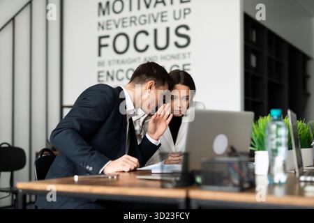 Colleagues confer at meetings with partners whispering to each other on their thoughts Stock Photo