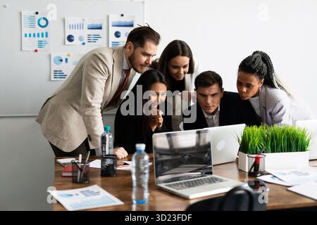 Marketing team. Group of young modern people in smart casual wear discussing something while working in the creative office Stock Photo