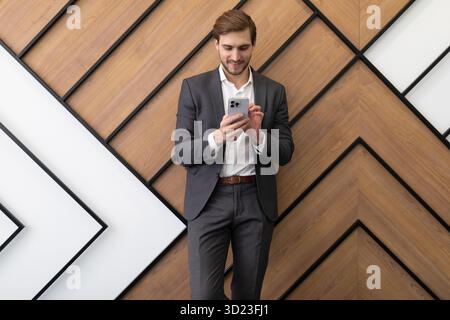 Businessman broker typing a message in a smartphone while in the office Stock Photo