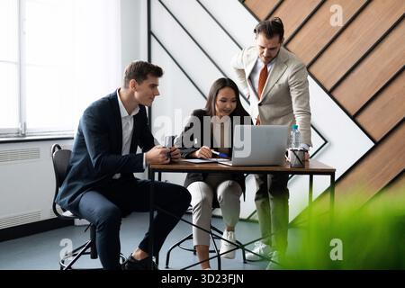 Workflow discussion of business plans in the office between colleagues Stock Photo