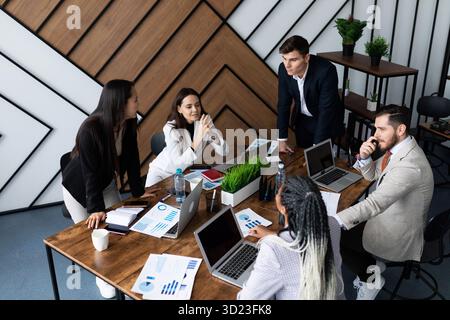 Business meeting in the office on the background of a large table with laptops Stock Photo