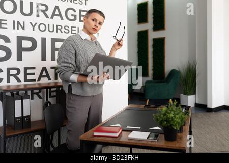 Woman specialist with a laptop in her hands in the office Stock Photo