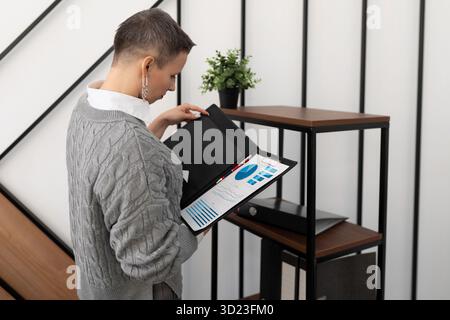 Woman checking documents in a folder in a stylish office Stock Photo