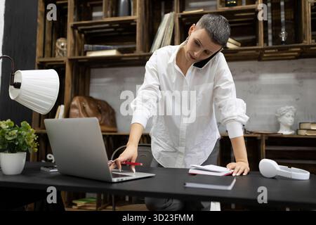 Elegant businesswoman working in the company behind a laptop Stock Photo
