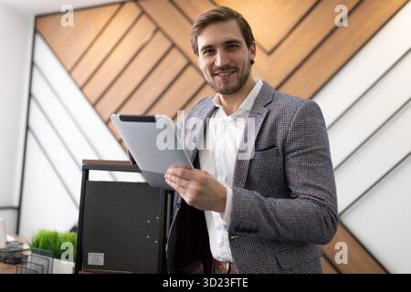 Young male Businessman with a tablet in his hands on the background of the office Stock Photo