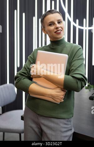Portrait of a successful mature female programmer against the backdrop of a stylish office Stock Photo