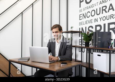 Ambitious young successful businessman working on laptop in office Stock Photo