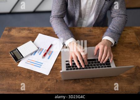 Businessman working on laptop with documents calculator on table top view Stock Photo