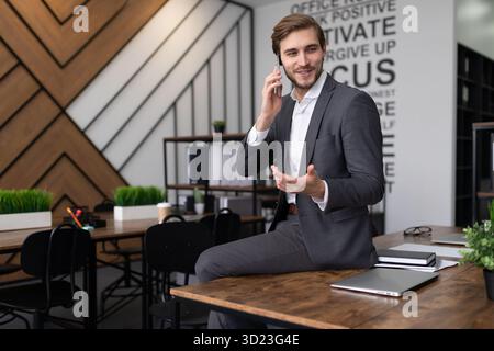 Pretty successful businessman is talking on the phone in the office Stock Photo
