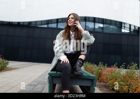 Young female student talking on the phone outside Stock Photo
