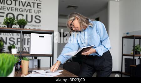 Caucasian woman accountant working in office with papers Stock Photo